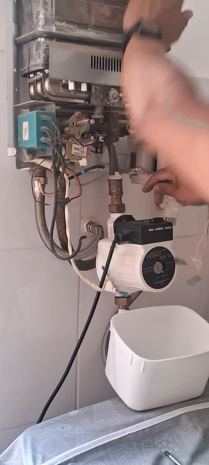 Técnico da V8 Aquecedores consertando um aquecedor a gás no Rio de Janeiro
